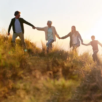 four people holding hands near a sunrise in new york