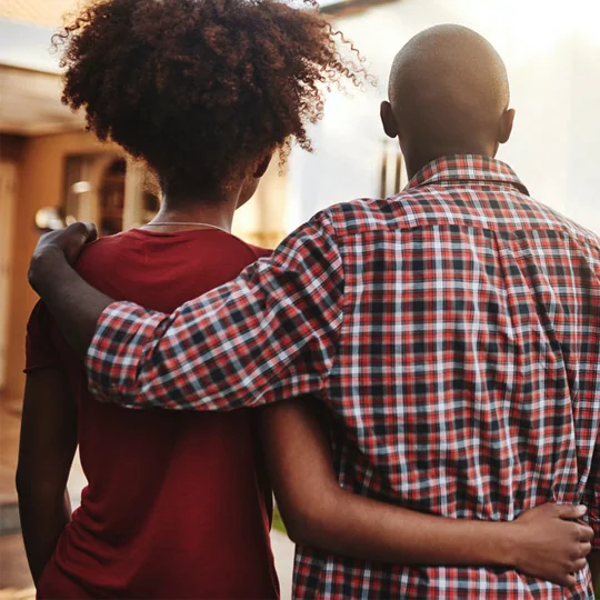 Couple in front of their new home