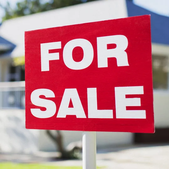 For sale sign in front of house